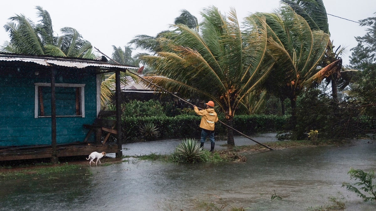 A man fixes the roof of a home surrounded by floodwaters brought on by Hurricane Eta in Wawa, Nicaragua, Tuesday, Nov. 3, 2020.
