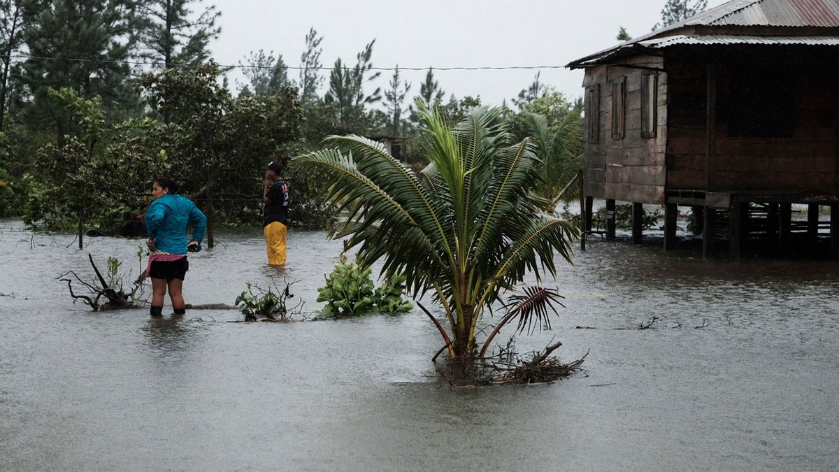 Residents stand outside a home surrounded by floodwaters brought on by Hurricane Eta in Wawa, Nicaragua, Tuesday, Nov. 3, 2020.