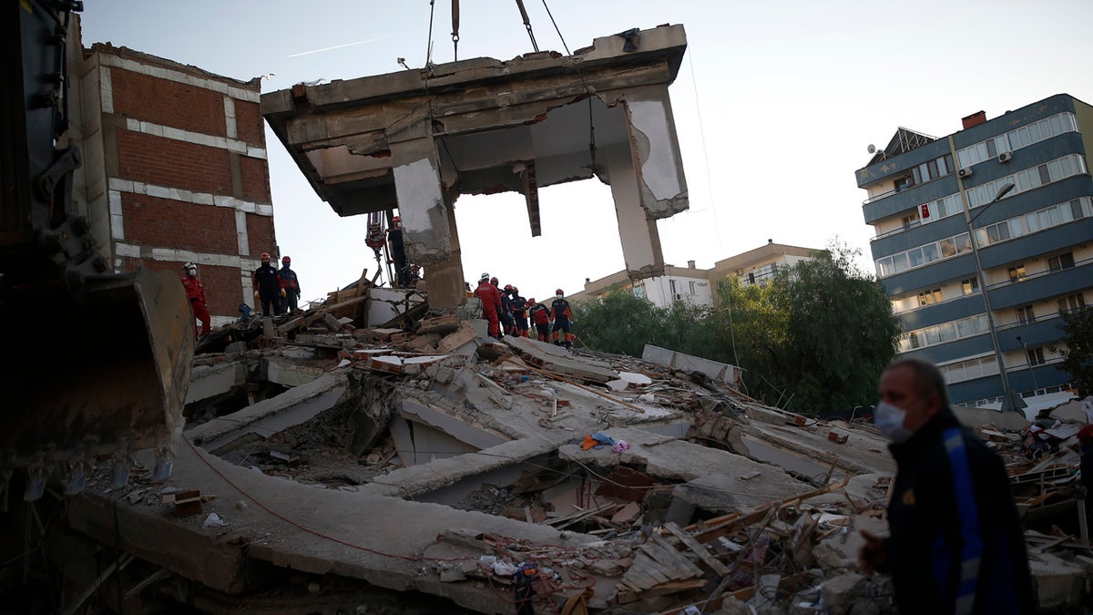 Members of rescue services search for survivors in the debris of a collapsed building in Izmir, Turkey, Saturday, Oct. 31, 2020.