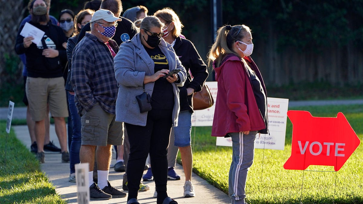 People wear protective face masks as they wait in line to vote at the Bell Shoals Baptist Church on election day Tuesday, Nov. 3, 2020, in Brandon, Fla. (AP Photo/Chris O'Meara)