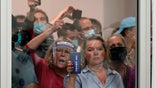 People wanting to be election challengers yell as they look through the windows of the central counting board as police were helping to keep additional challengers from entering due to overcrowding, Wednesday, Nov. 4, 2020, in Detroit. (AP Photo/Carlos Osorio)