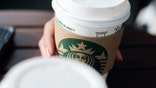 La Libertad, El Salvador - April 30, 2012: A disposable coffee cup with the Starbucks franchise logo on it.