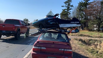 Wisconsin trooper stops driver hauling snowmobile atop sedan