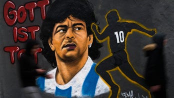 Spanish soccer player sits during Diego Maradona tribute before match