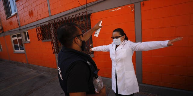 <br>
Dr. Monserrat Castaneda is sprayed with a disinfectant after conducting a COVID-19 test inside a home, in the Venustiano Carranza borough of Mexico City, Thursday, Nov. 19, 2020. (AP Photo/Rebecca Blackwell)