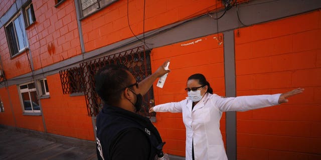 <br>
Dr. Monserrat Castaneda is sprayed with a disinfectant after conducting a COVID-19 test inside a home, in the Venustiano Carranza borough of Mexico City, Thursday, Nov. 19, 2020. (AP Photo/Rebecca Blackwell)