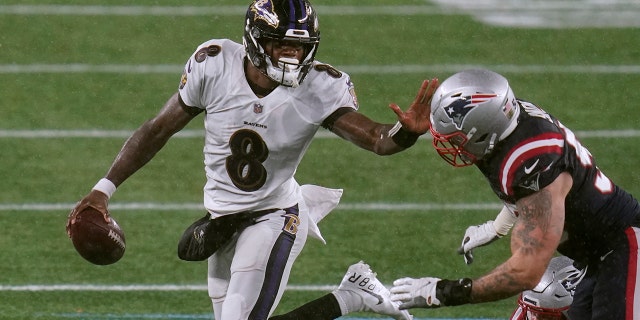 Baltimore Ravens quarterback Lamar Jackson, 왼쪽, tries to elude New England Patriots defensive end John Simon in the second half of an NFL football game, 일요일, 11 월. 15, 2020, in Foxborough, Mass. (AP Photo/Charles Krupa)