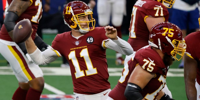Washington Football Team quarterback Alex Smith (11) throws a pass from the pocket as Brandon Scherff (75) and Wes Schweitzer (71) defend against pressure in the first half of an NFL football game against the Dallas Cowboys in Arlington, Texas, Thursday, Nov. 26, 2020.