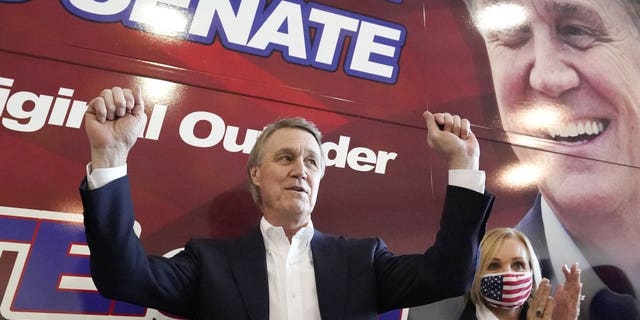 In this Nov. 2, 2020 photo, Sen. David Perdue and his wife Bonnie react during a campaign stop at Peachtree Dekalb Airport in Atlanta. Perdue earlier this year was cleared of wrongdoing by multiple investigations into different stock trades earlier this year. Perdue has stopped trading individudal stocks. (AP Photo/John Bazemore)