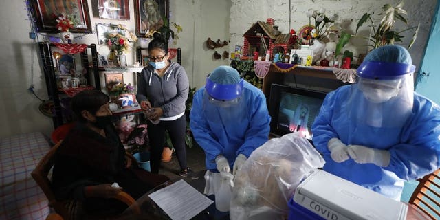 <br>
Doctors Delia Caudillo, center, and Monserrat Castaneda, prepare to conduct a COVID-19 test on 82-year-old Modesta Caballero Serrano, as her granddaughter gives her antibacterial gel, at her home in the Venustiano Carranza borough of Mexico City, Thursday, Nov. 19, 2020. (AP Photo/Rebecca Blackwell)