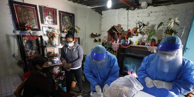 <br>
Doctors Delia Caudillo, center, and Monserrat Castaneda, prepare to conduct a COVID-19 test on 82-year-old Modesta Caballero Serrano, as her granddaughter gives her antibacterial gel, at her home in the Venustiano Carranza borough of Mexico City, Thursday, Nov. 19, 2020. (AP Photo/Rebecca Blackwell)