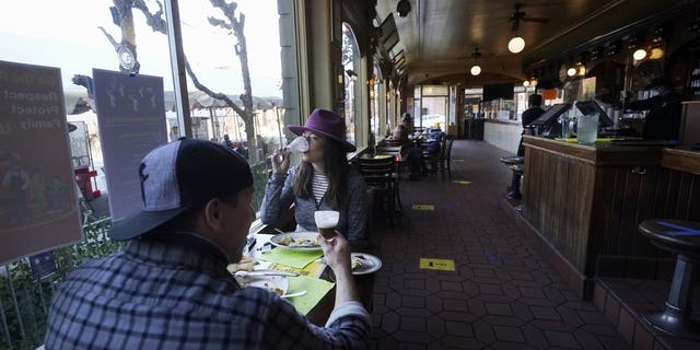 In this Nov. 12 photo, a couple eat inside at the Buena Vista Cafe during the coronavirus outbreak in San Francisco. With the coronavirus coming back with a vengeance across the country and the U.S. facing a long, dark winter, governors and other elected officials are showing little appetite for reimposing the kind of lockdowns and large-scale business closings seen last spring. (AP Photo/Jeff Chiu, File)
