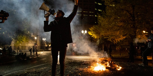 A Black Lives Matter protester chants slogans on Wednesday early morning, Nov. 4, 2020, in Portland, Ore. (AP Photo/Paula Bronstein)
