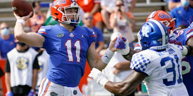 Florida quarterback Kyle Trask (11) throws a pass as Kentucky linebacker Jamar Watson (31) rushes during the first half of an NCAA college football game, Saturday, Nov. 28, 2020, in Gainesville, Fla. (AP Photo/John Raoux)