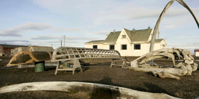 In this Aug. 12, 2005, file di foto, a skin boat display sits next to whale bones and an arch made of a whale jaw on the beach at Brower's Cafe in Barrow, Alaska.