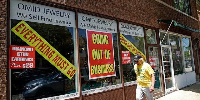 A man walks past a retail store going out of business due to the coronavirus pandemic in Winnetka, Ill., June 23, 2020.