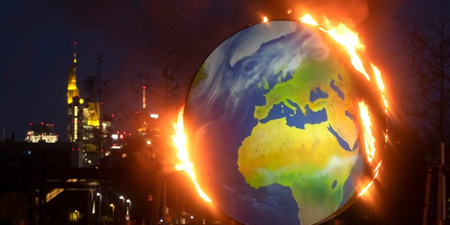 A makeshift globe burns in front of the European Central Bank in Frankfurt, Germany, Wednesday, Oct. 21, 2020. Activists of the so-called "KoalaKollektiv," an organization asking for climate justice, protested with the burning of the globe against the ECB's climate policy. (AP Photo/Michael Probst)