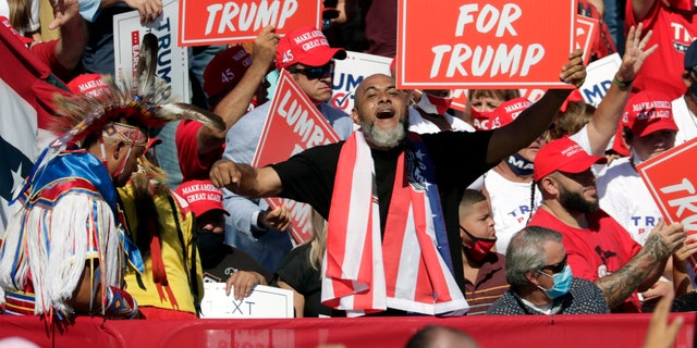 Supporters hold "Lumbees for Trump" signs as President Donald Trump speaks during a campaign rally at the Robeson County Fairgrounds in Lumberton, N.C., Saturday, Oct. 24, 2020. (AP Photo/Chris Seward)
