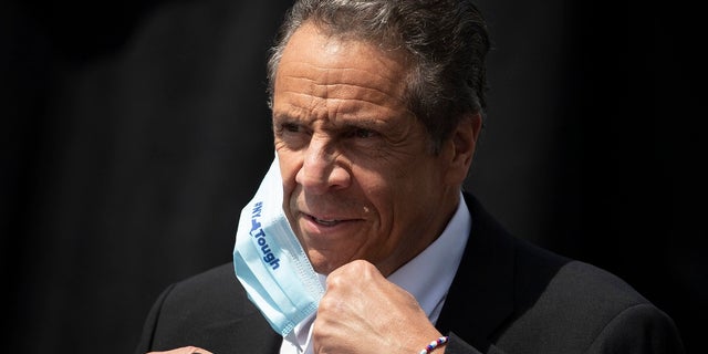 In this June 15, 2020, file photo, New York Gov. Andrew Cuomo removes a mask as he holds a news conference in Tarrytown, N.Y. On Wednesday, Cuomo announced new coronavirus restrictions that take effect Friday. (AP Photo/Mark Lennihan, File)