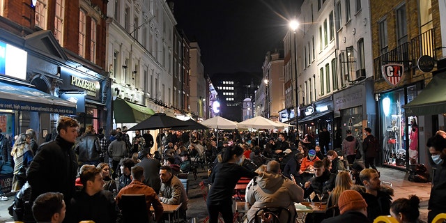 People dine and take drinks on Old Compton Street in the Soho area of central London, Saturday, Oct. 31, 2020. Earlier Saturday British Prime Minister Boris Johnson announced England will start a month long lockdown next week. Johnson says the new measures will begin Thursday and last until Dec. 2. (AP Photo/Alberto Pezzali, Pool)