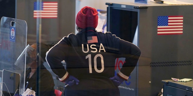 A poll worker wearing patriotic clothing pauses on the last day of early voting, Sunday, Nov. 1, 2020, at Columbia University's Forum in the West Harlem neighborhood of New York. (AP Photo/Kathy Willens)
