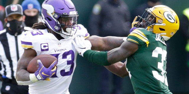 Minnesota Vikings' Dalvin Cook tries to get padt Green Bay Packers' Josh Jackson during the second half of an NFL football game Sunday, Nov. 1, 2020, in Green Bay, Wis. (AP Photo/Mike Roemer)