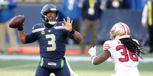 Seattle Seahawks quarterback Russell Wilson (3) makes a touchdown pass to wide receiver DK Metcalf (not shown) as San Francisco 49ers safety Marcell Harris, right, pressures during the first half of an NFL football game, Sunday, Nov. 1, 2020, in Seattle. (AP Photo/Scott Eklund)