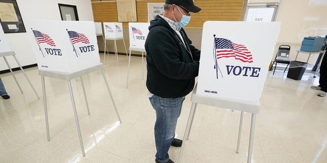 FILE - In this Oct. 20, 2020 file photo, Kelly Wingfield, of Urbandale, Iowa, fills out his ballot during early voting in the general election, in Adel, Iowa. (AP Photo/Charlie Neibergall, File)