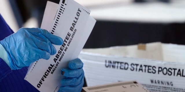 A worker at the Fulton County Board of Registration and Elections works to process absentee ballots at the State Farm Arena Monday, in Atlanta.