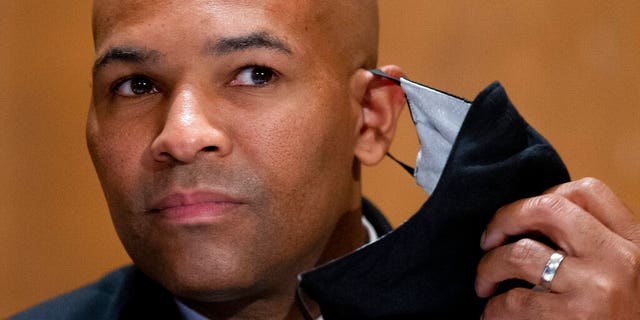 FILE - In this Sept. 9, 2020, 파일 사진, Surgeon General Jerome Adams takes off his face mask as he appears on Capitol Hill in Washington. A lawyer for Surgeon General Adams pleaded not guilty Monday, 11 월. 2, 2020, on behalf of Adams, who was cited by Honolulu police for being in a closed park during a trip to help Hawaii cope with a spike in coronavirus cases. Adams didn't travel to Hawaii for the arraignment. (Michael Reynolds/Pool vi파일, File)