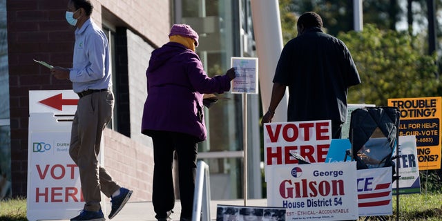 Voters are assisted at a polling location at the South Regional Library in Durham, N.C., Tuesday, Nov. 3, 2020. (AP Photo/Gerry Broome)