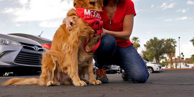 US Sen. Martha McSally, R-Arries., Hugs her dog Boomer at a polling station before congratulating voters on Tuesday, November 3, 2020, in Mesa, Ariz.  (AP Photo / Matt York)