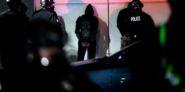 A man is detained by police on Election Day, Tuesday, Nov. 3, 2020, in Los Angeles. (AP Photo/Jae C. Hong)