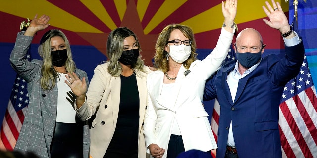 Le sénateur Mark Kelly, D-Ariz., Salue les partisans avec son épouse Gabrielle Giffords, deuxième à droite, et ses filles, Claire Kelly, à gauche, et Claudia Kelly, deuxième à gauche, lors d'une soirée électorale le mardi 3 novembre. , 2020 à Tucson, en Arizona. Kelly est réélue en 2022. (AP Photo / Ross D. Franklin)