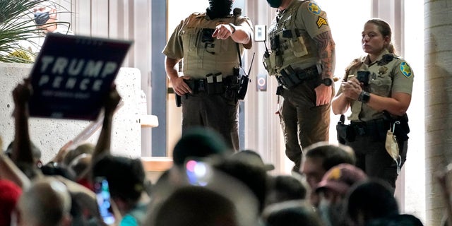 dMaricopa County sheriff's Deputies stand at the door of the Maricopa County Recorder's Office as Trump supporters rally outside Wednesday in Phoenix. (Associated Press)