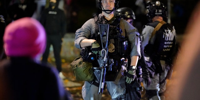 A police official looks on during a protest after the Nov. 3 elections, Wednesday, Nov. 4, 2020, in Seattle. (AP Photo/Ted S. Warren)