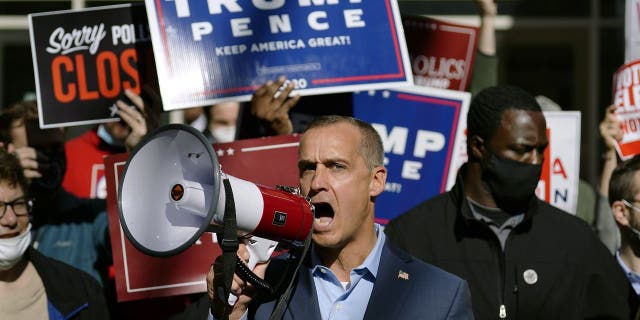 President Donald Trump's campaign advisor Corey Lewandowski, center, speaks about a court order obtained to grant more access to vote counting operations at the Pennsylvania Convention Center, Thursday, Nov. 5, 2020, in Philadelphia, following Tuesday's election. (AP Photo/Matt Slocum)