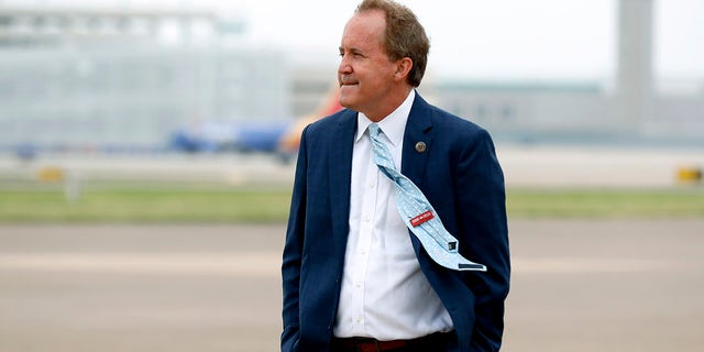 In this June 28, 2020, file photo, Texas Attorney General Ken Paxton waits on the flight line for the arrival of Vice President Mike Pence at Love Field in Dallas. Paxton had an extramarital affair with a woman whom he later recommended for a job with the wealthy donor now at the center of criminal allegations against him, according to two people who said Paxton told them about the relationship. (AP Photo/Tony Gutierrez, File)