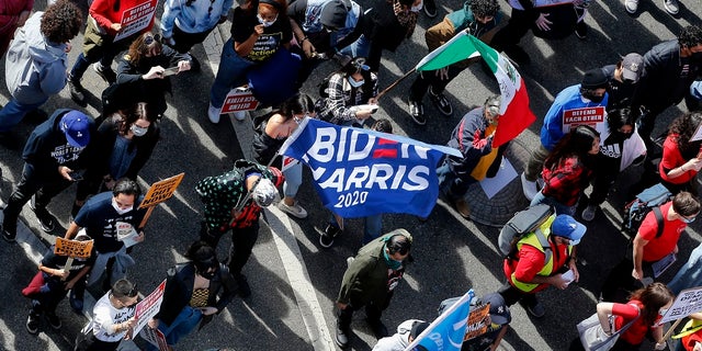 Demonstrators march to advocate protecting the voting results after former vice president and Democratic presidential candidate Joe Biden was announced as the winner over Pres. Donald Trump to become the 46th president of the United States in Los Angeles on Saturday. (AP Photo/Ringo H.W. Chiu)