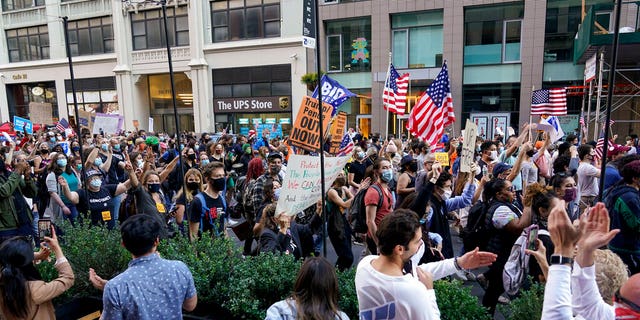 Outdoor diners cheer as as demonstrators march through the streets after former vice president and Democratic presidential candidate Joe Biden was announced as the winner over Pres. Donald Trump Nov. 7.  (AP Photo/Seth Wenig)