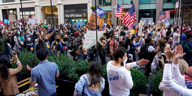 Outdoor diners cheer as as demonstrators march through the streets after former vice president and Democratic presidential candidate Joe Biden was announced as the winner over Pres. Donald Trump Nov. 7. (AP Photo/Seth Wenig)