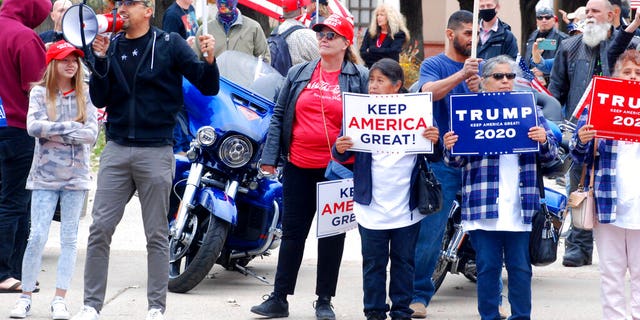 Hundreds of supporters of President Donald Trump staged a defiant rally outside the New Mexico state Capitol building in Santa Fe, N.M., on Nov. 7. They waved flags, chanted "four more years," and cheered and jeered at passing cars. A dozen supporters of Democrat Joe Biden gathered blocks away at the city's central plaza amid a heavy police presence. Democrat Joe Biden won the vote for New Mexico in the Nov. 3 election. (AP Photo/Morgan Lee)