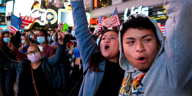 People celebrate in Times Square after former Vice President Joe Biden was announced as the winner against President Donald Trump to become the 46th President of the United States.