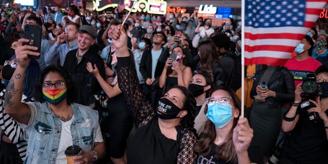 People in New York's Times Square look up at a monitor as President-elect Joe Biden addresses the nation, Saturday, Nov. 7, 2020. (Associated Press)