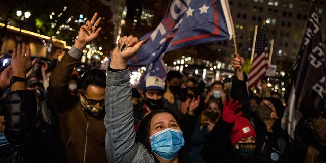 Brittney Hernandez celebrates Joe Biden's win in the presidential election, Saturday, Nov. 7, 2020, in Portland, Ore. (AP Photo/Paula Bronstein)