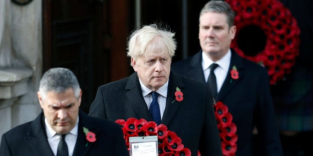 Britian's Prime Minister Boris Johnson carries a wreath, during the Remembrance Sunday service at the Cenotaph, in Whitehall, London, Sunday Nov. 8, 2020. (Peter Nicholls/Pool Photo via AP)