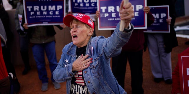 A supporter of President Donald Trump grabbed her heart during a protest against the election outside the Clark County Elections Department, Sunday, November 8, 2020, in North Las Vegas.