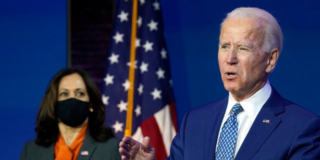 President-elect Joe Biden speaks Monday, Nov. 9, 2020, at The Queen Theater in Wilmington, Del., as Vice President-elect Kamala Harris listens. Both will stump for the Georgia Democratic Senate candidates in the final week of the campaign. (AP Photo/Carolyn Kaster)