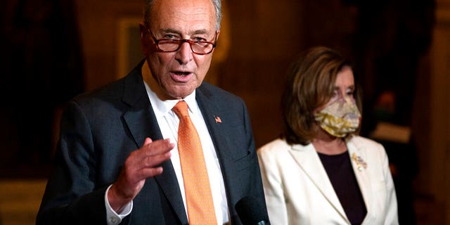 FILE: Senate Minority Leader Sen. Chuck Schumer of N.Y., speaks to reporters as House Speaker Nancy Pelosi of Calif., listens at right on Capitol Hill in Washington.