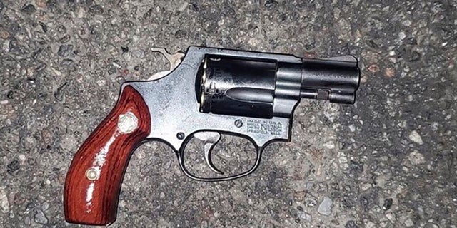 In this photo provided by the New York Police Department, a gun lies on the sidewalk that police say was used in the attempted hijacking of an off-duty NYPD officer in early November 11 in Brooklyn .  The city is grappling with an upsurge in violent crime and a growing number of brazen criminals following two people pushing down subway tracks in separate incidents that happened hours apart this week.  (NYPD via AP)